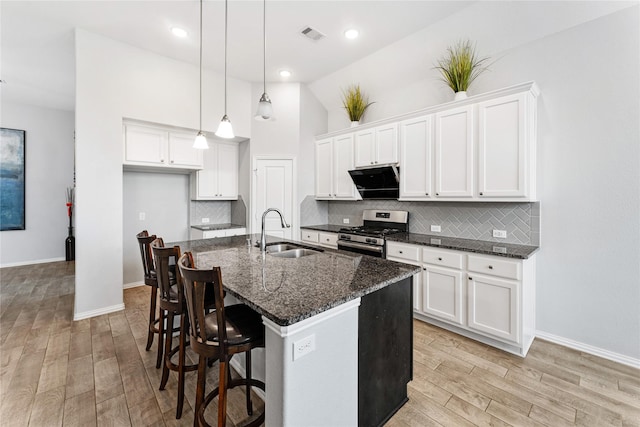 kitchen featuring a sink, light wood-style floors, stainless steel range with gas cooktop, and white cabinetry