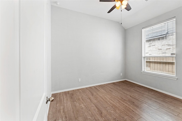 unfurnished room featuring a ceiling fan, vaulted ceiling, wood finished floors, and baseboards