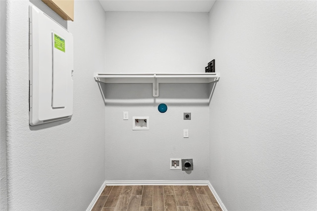 laundry area featuring baseboards, dark wood finished floors, laundry area, hookup for a washing machine, and hookup for an electric dryer