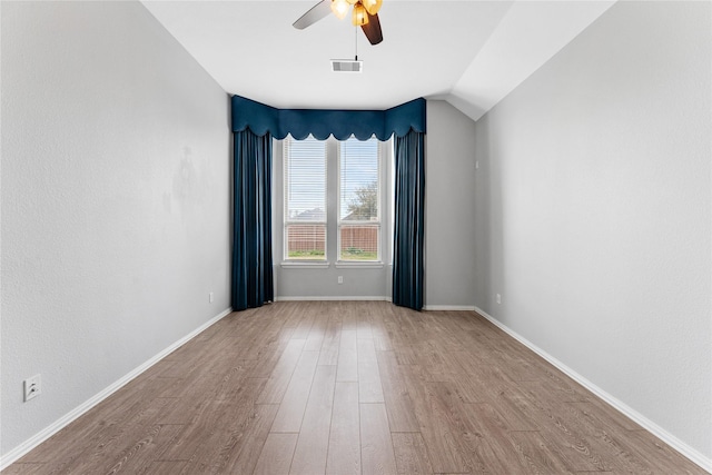 spare room featuring visible vents, baseboards, a ceiling fan, and wood finished floors