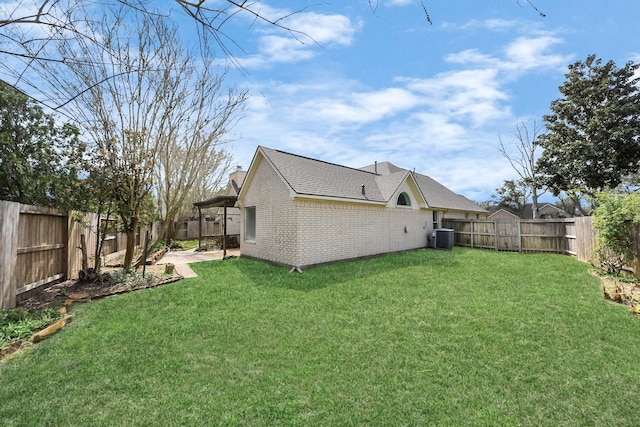 view of yard featuring central AC unit, a fenced backyard, and a patio area