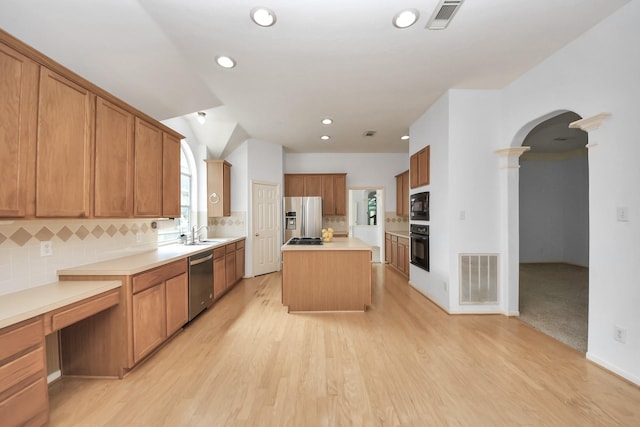 kitchen with arched walkways, visible vents, a center island, and black appliances