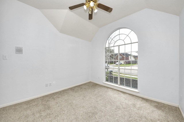 carpeted empty room with baseboards, ceiling fan, and vaulted ceiling