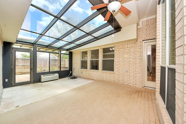 unfurnished sunroom with a wall unit AC, a ceiling fan, and vaulted ceiling