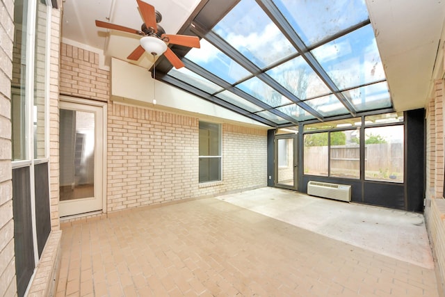 unfurnished sunroom with lofted ceiling, a wall mounted air conditioner, and ceiling fan