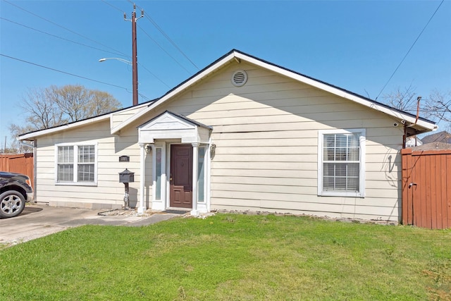 bungalow with a front lawn and fence