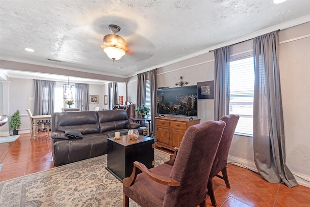 living area with tile patterned floors, baseboards, a textured ceiling, and ornamental molding