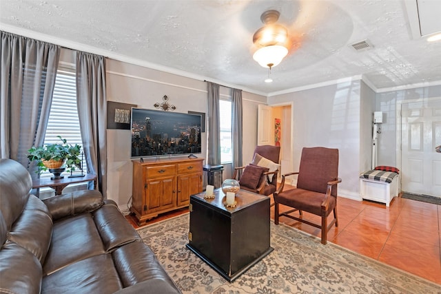 living room featuring light tile patterned floors, visible vents, a textured ceiling, and ornamental molding