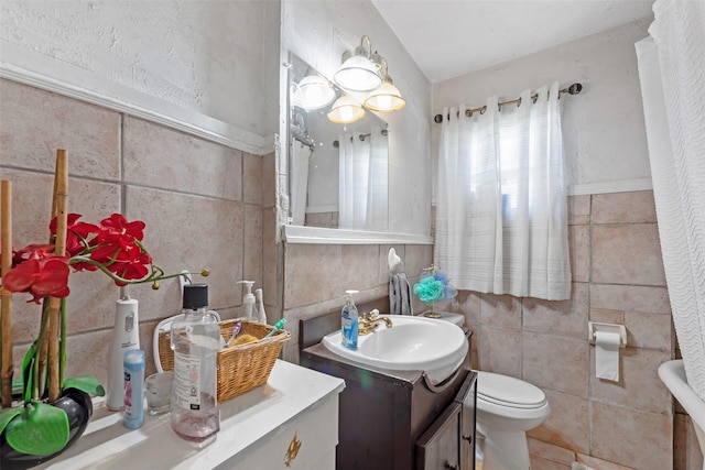 full bath with vanity, tile walls, and toilet