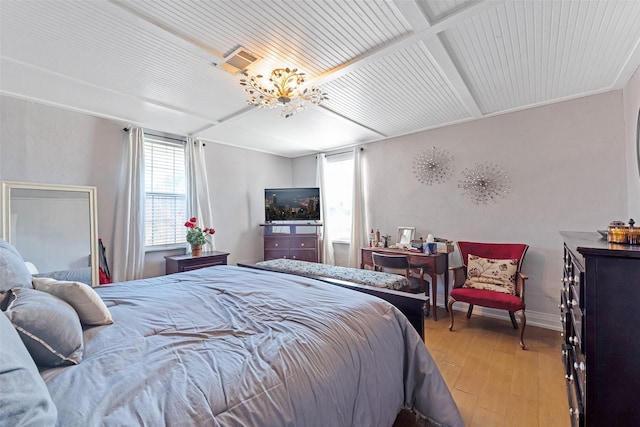 bedroom with an inviting chandelier, beamed ceiling, baseboards, and light wood finished floors