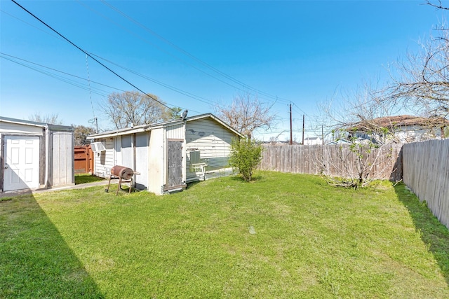 view of yard with a storage unit, an outbuilding, and a fenced backyard