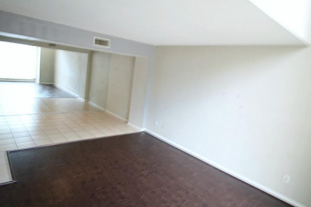 spare room with wood finished floors, baseboards, and visible vents