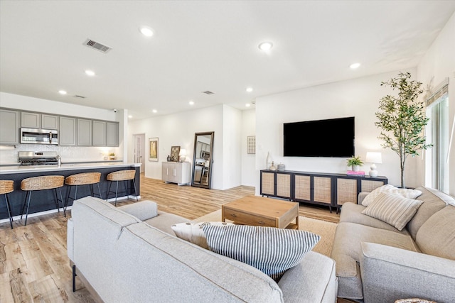 living area featuring recessed lighting, visible vents, and light wood-style flooring