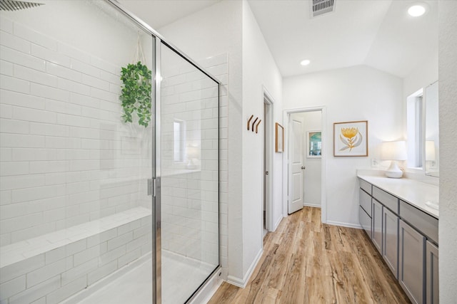 full bath featuring vanity, wood finished floors, visible vents, and a stall shower