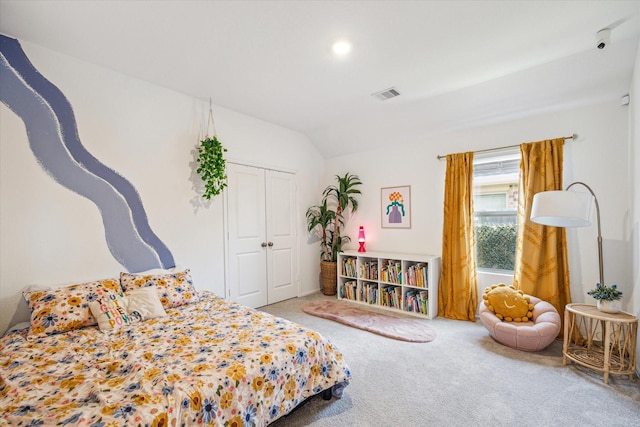 carpeted bedroom featuring visible vents, a closet, and vaulted ceiling