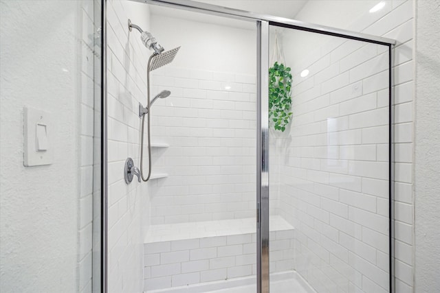 full bath with a shower stall and a textured wall