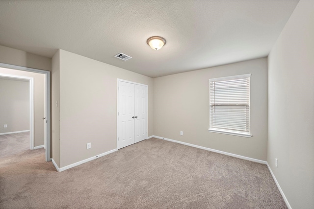 unfurnished bedroom with visible vents, baseboards, and carpet flooring