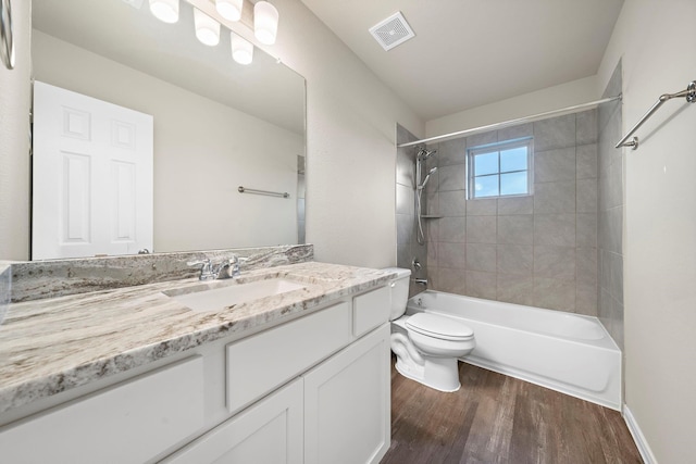 bathroom featuring visible vents, toilet, shower / bathtub combination, wood finished floors, and vanity