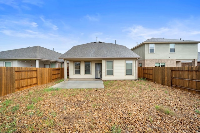 back of house with a fenced backyard, a patio, and roof with shingles