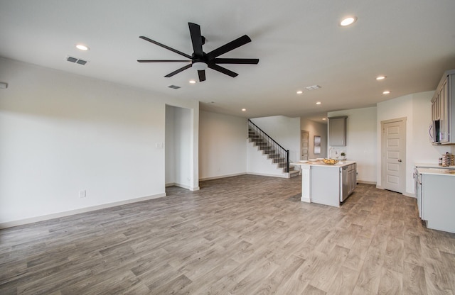 unfurnished living room featuring visible vents, stairs, recessed lighting, light wood-style flooring, and a ceiling fan