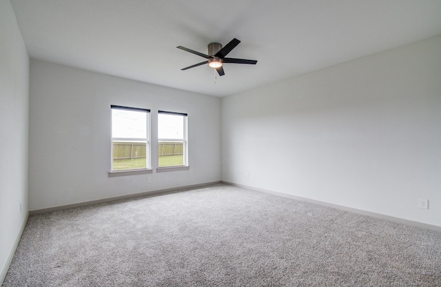 carpeted empty room with baseboards and ceiling fan