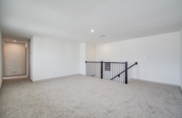 spare room featuring recessed lighting, carpet, visible vents, and baseboards