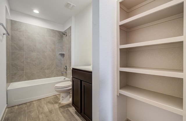 full bath featuring vanity, wood finished floors, visible vents, shower / tub combination, and toilet