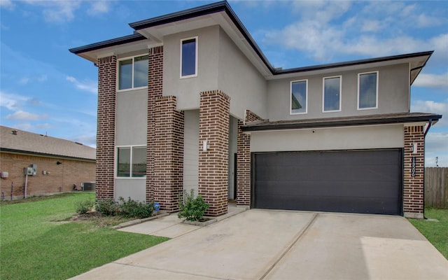 view of front of home featuring stucco siding, a front lawn, a garage, and driveway