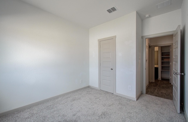 unfurnished bedroom featuring baseboards, visible vents, and carpet floors