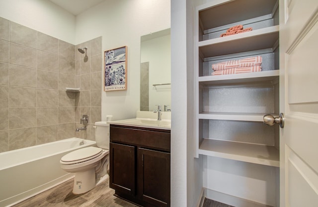 bathroom featuring vanity, toilet, wood finished floors, and shower / washtub combination