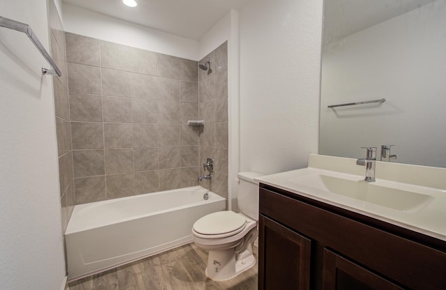 bathroom featuring vanity, toilet, shower / bathing tub combination, and wood finished floors