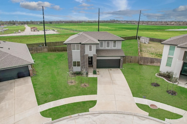 view of front of home featuring driveway, a front lawn, roof with shingles, an attached garage, and brick siding