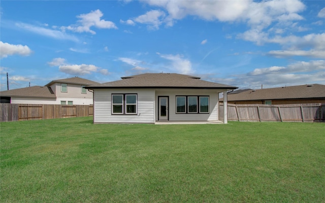 back of house featuring a yard, a fenced backyard, and a shingled roof