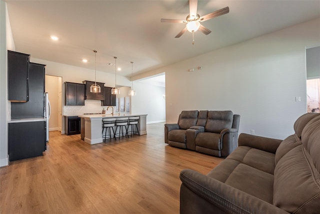 living room featuring recessed lighting, baseboards, light wood-type flooring, and a ceiling fan