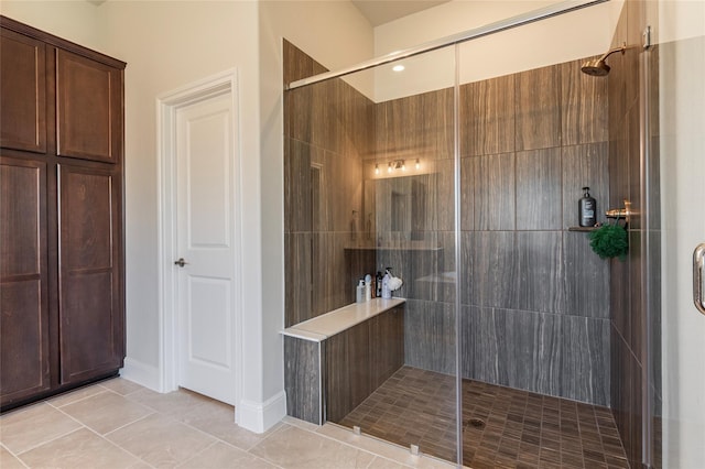 bathroom with tile patterned flooring and a tile shower