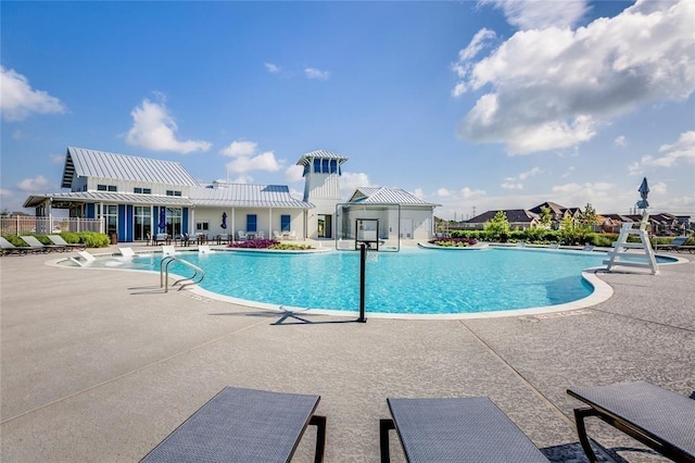 community pool featuring a patio and fence