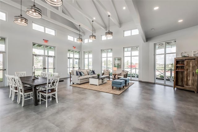 dining space with beamed ceiling, recessed lighting, concrete floors, and a towering ceiling