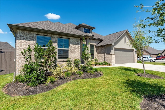 view of front of house featuring roof with shingles, an attached garage, concrete driveway, a front lawn, and brick siding