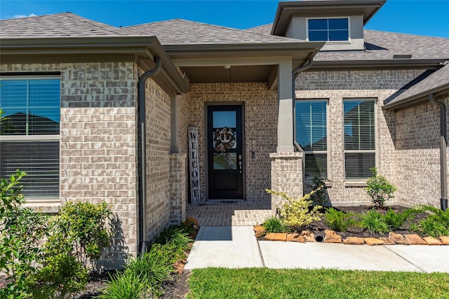 entrance to property with brick siding and roof with shingles