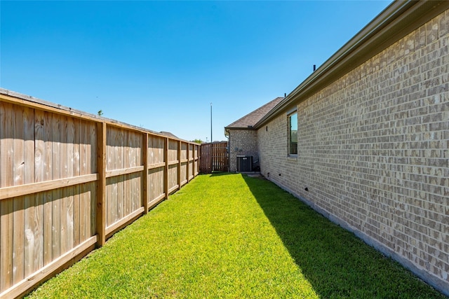 view of yard with central AC and fence private yard