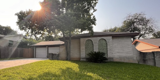 view of front of property with a front lawn, fence, a garage, stone siding, and driveway