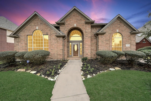 traditional-style home with brick siding and a yard