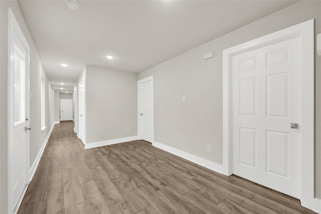 empty room featuring recessed lighting, baseboards, and wood finished floors