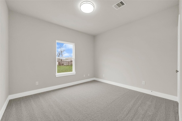 carpeted spare room featuring visible vents and baseboards