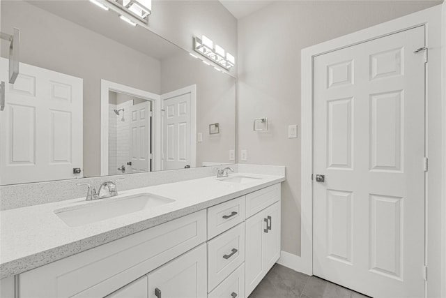 full bathroom featuring double vanity, a shower, and a sink