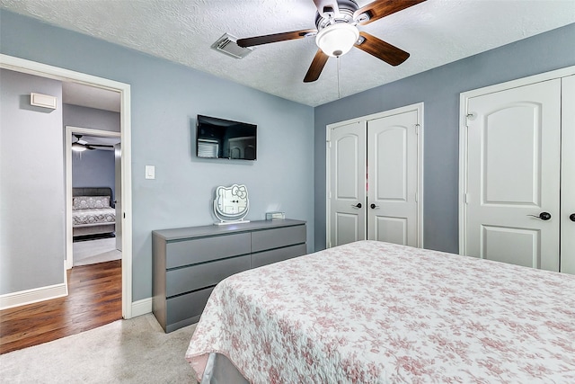 bedroom with visible vents, ceiling fan, a textured ceiling, and baseboards