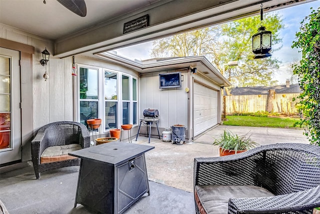 view of patio / terrace featuring a grill, concrete driveway, a ceiling fan, and fence