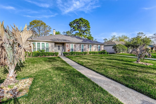 single story home featuring a front lawn, brick siding, and a chimney