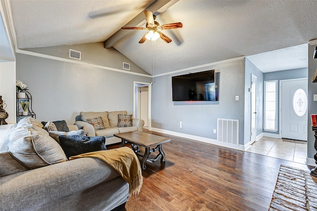 living room with vaulted ceiling with beams, wood finished floors, visible vents, and ceiling fan