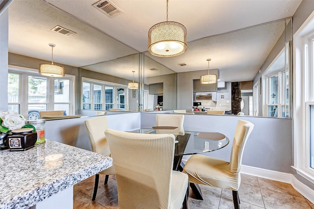 dining space with light tile patterned flooring, baseboards, and visible vents